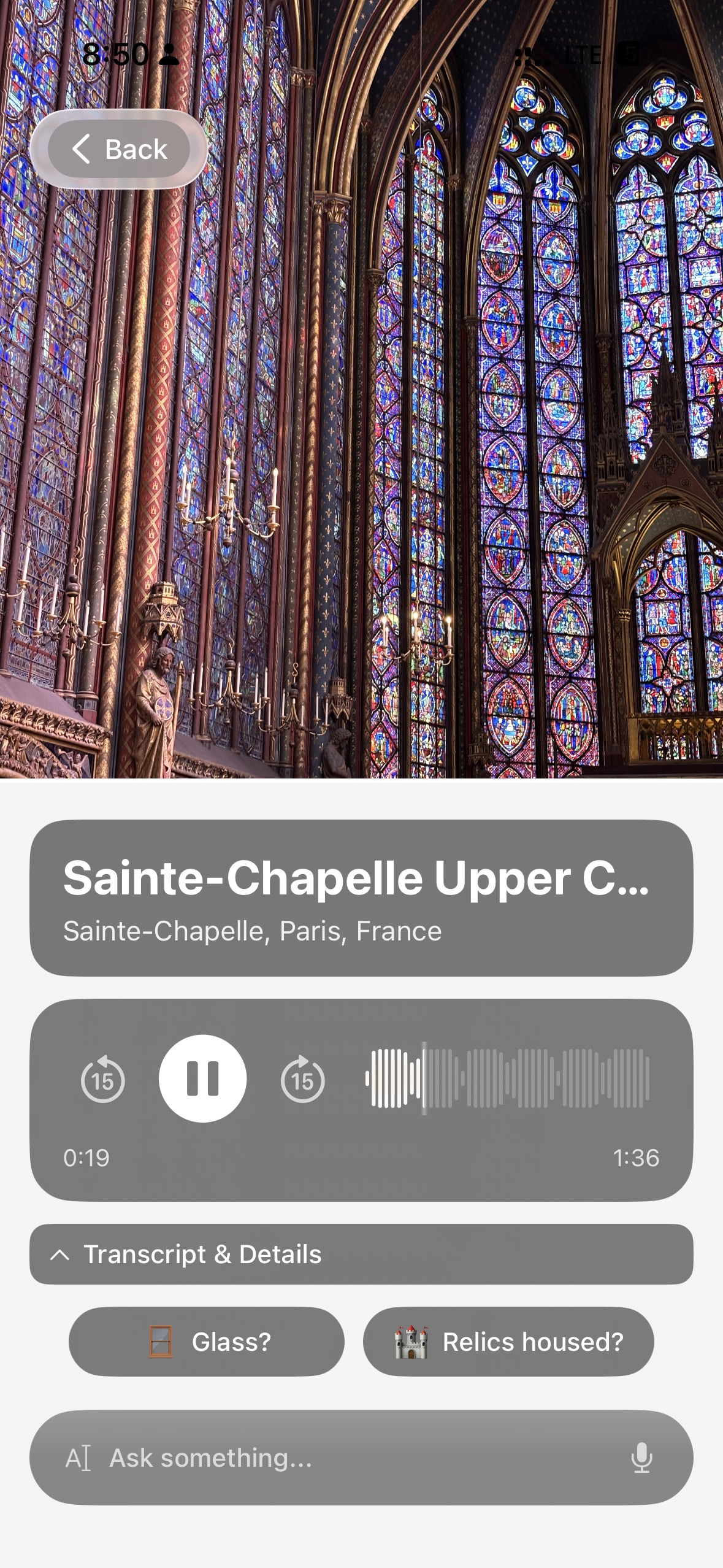 Chiaro recognizing the upper chapel of Sainte-Chapelle in Paris, its stained glass walls lit from behind, with the audio guide playing and follow-up buttons about the glass and the relics.