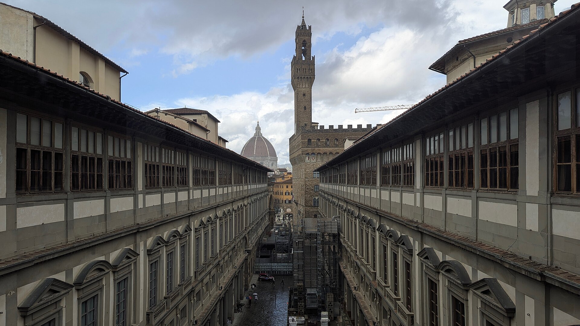 The Piazzale degli Uffizi looking back toward the building's entrance corridors, the spot where ticketed visitors line up for the timed-entry doors. The free-entry stub of the courtyard is the same square; the ticketed-entry door is on the east wing.